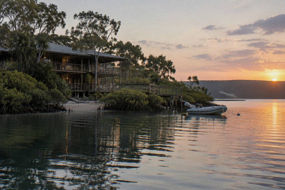 Resort building overlooking a calm bay at sunset