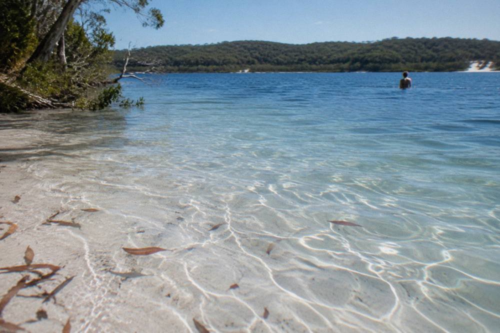 White silica sand shallows of a clear freshwater lake meeting deeper blue water