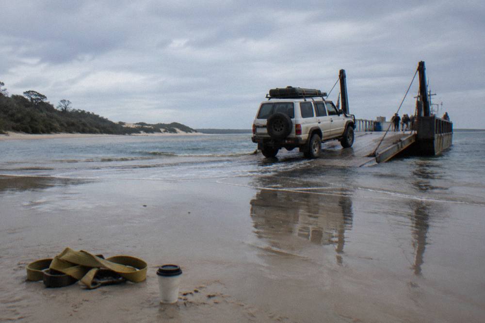 A four wheel drive vehicle driving along a firm sandy beach at low tide