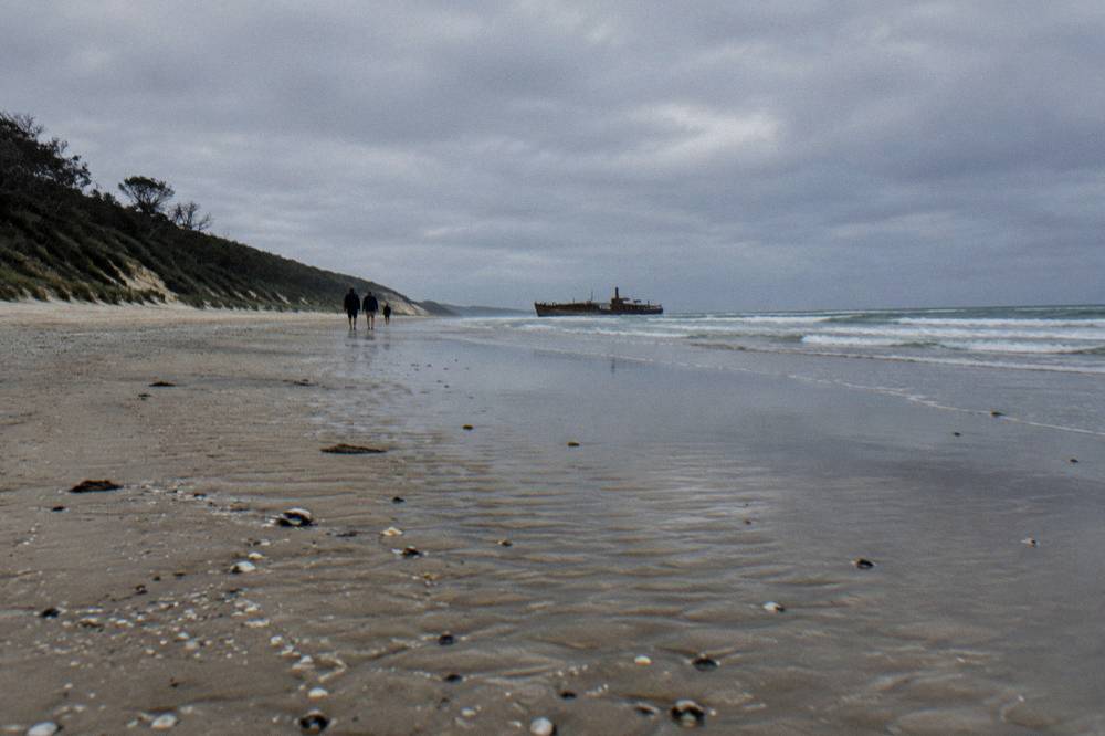 A wide empty sand beach at low tide with firm wet sand near the waterline